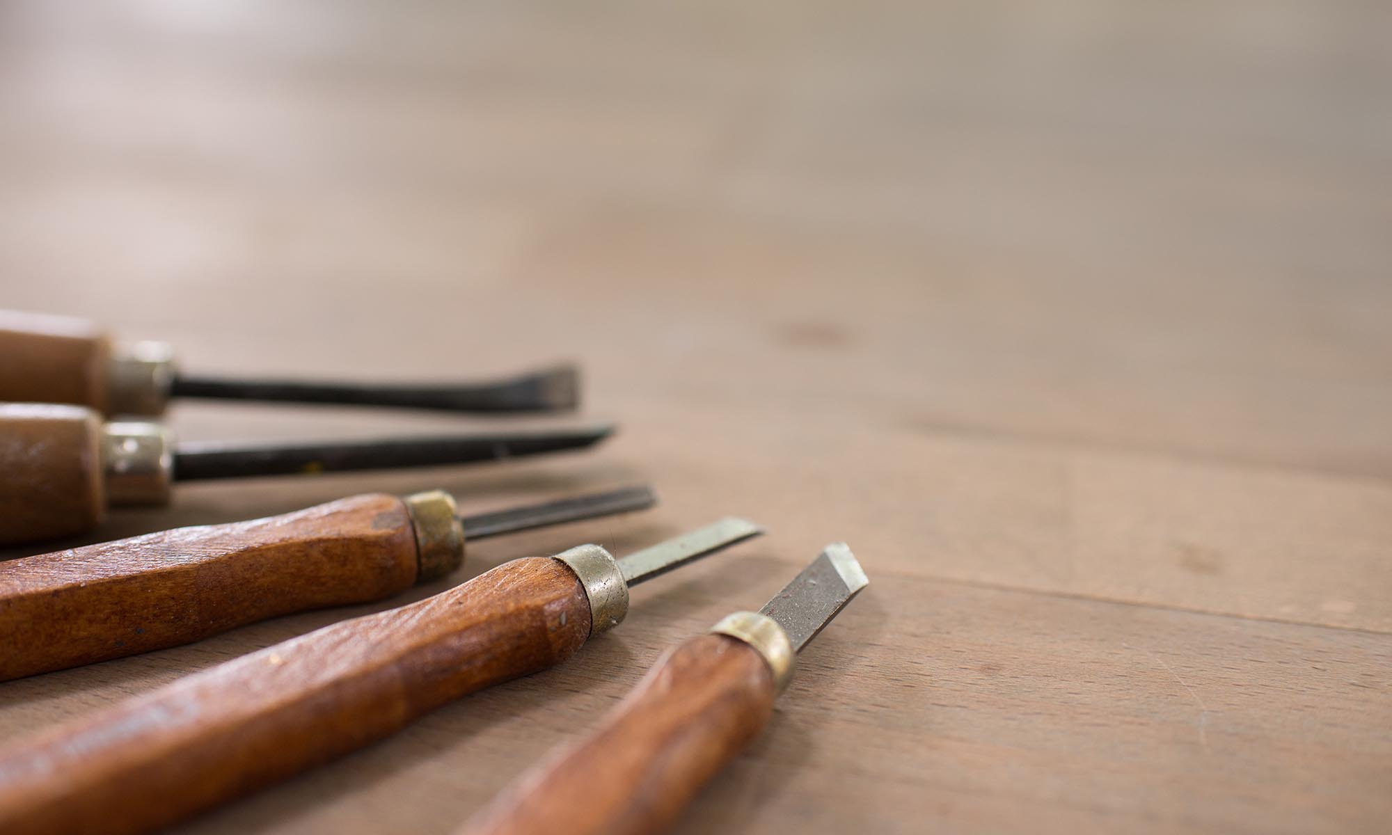 An image of wood carving tools on a table.